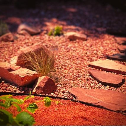 metal edging pieces in black colored powder coat, fastened together with nuts and bolts to create a tight and aligned connection. a landscape scene showing Red rocks and native plants from Southern utah