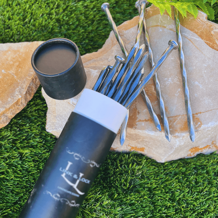 spiral nails made of stainless steel, with paper tube packaging, laying on a flagstone, on top of turf grass