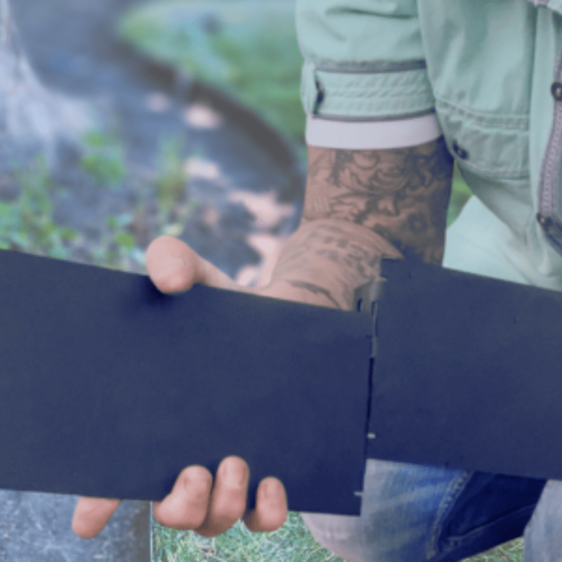 a professional, holding four inch tall metal edging, demonstrating how to slide together using easy and quick features